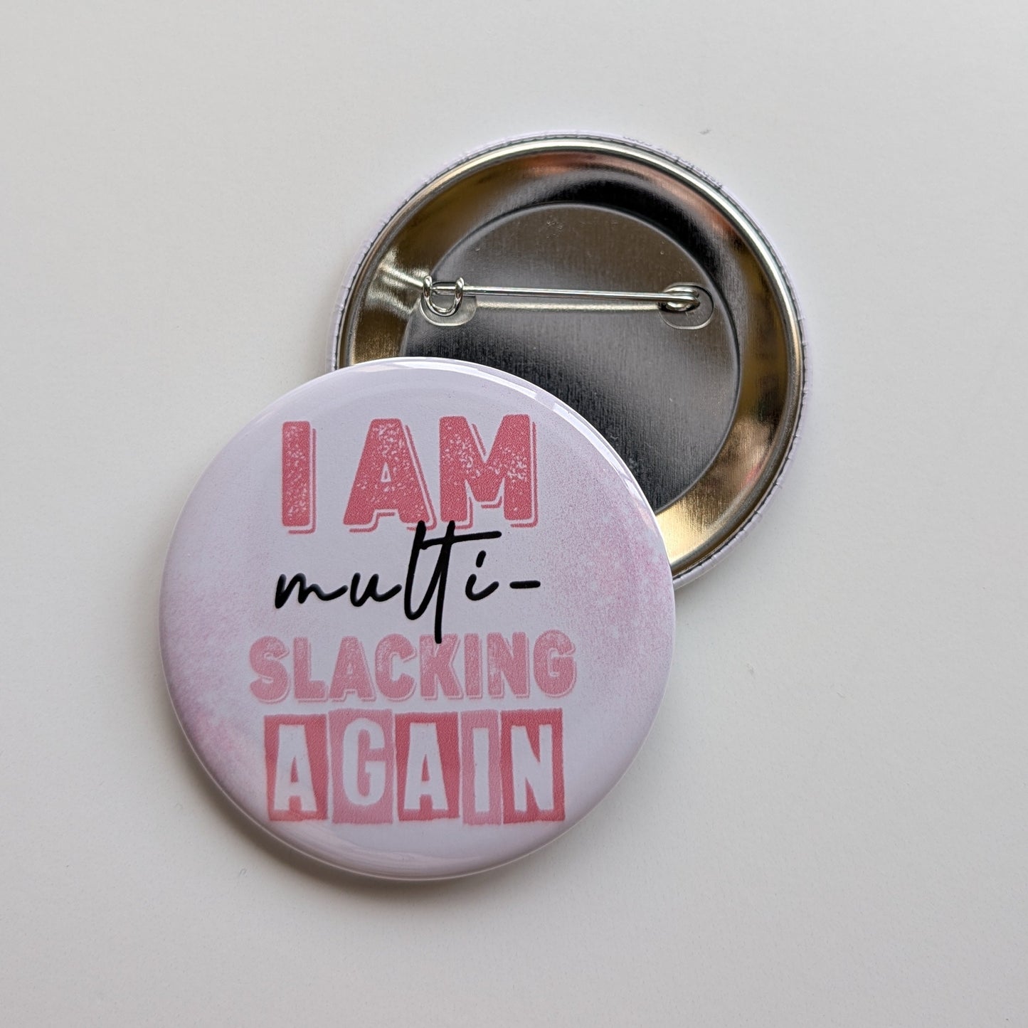 Button badge with text 'I AM multi-slacking AGAIN' on a white background
