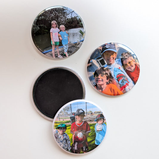 Four round photo magnets on a white background