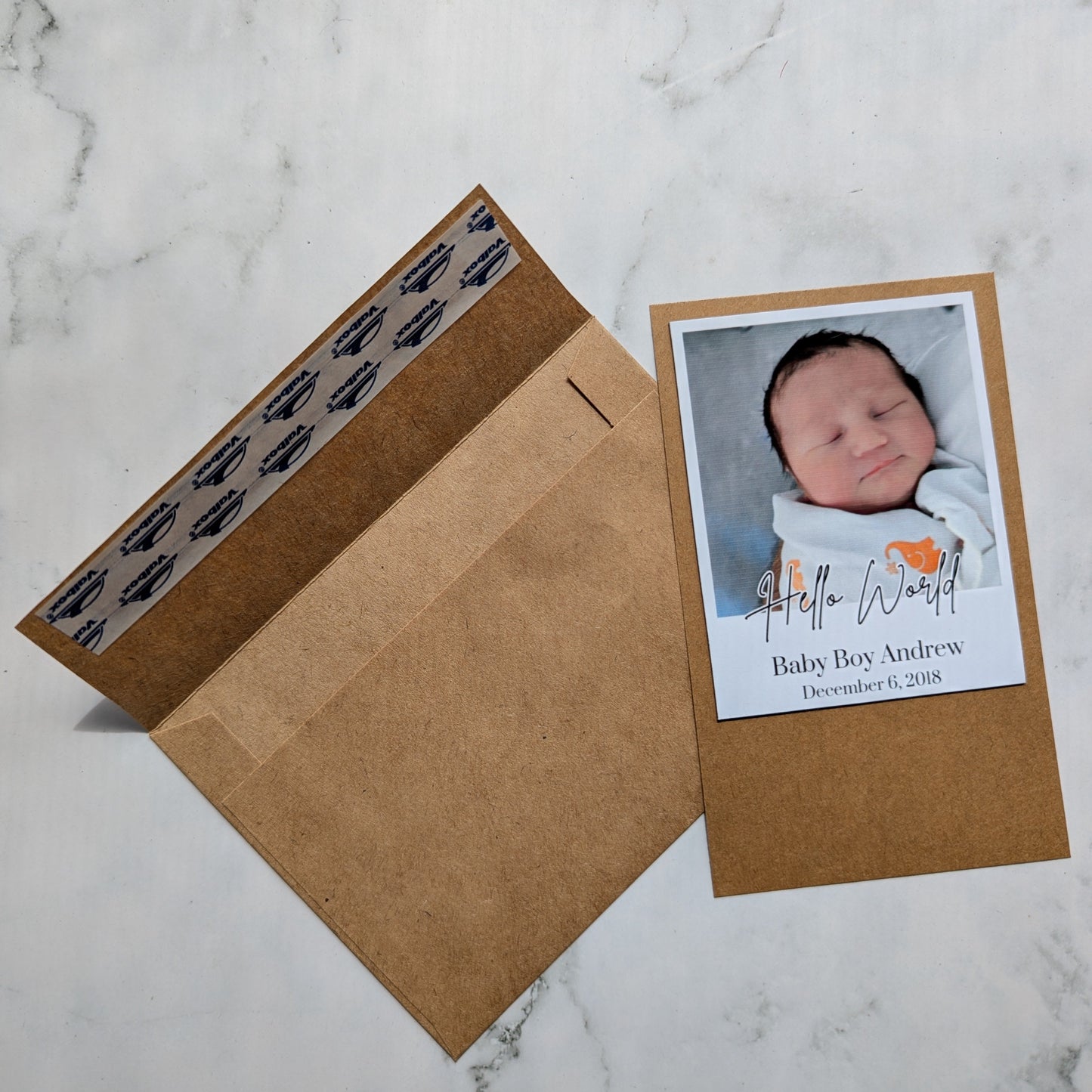 Baby photo magnet with envelope on a marble surface