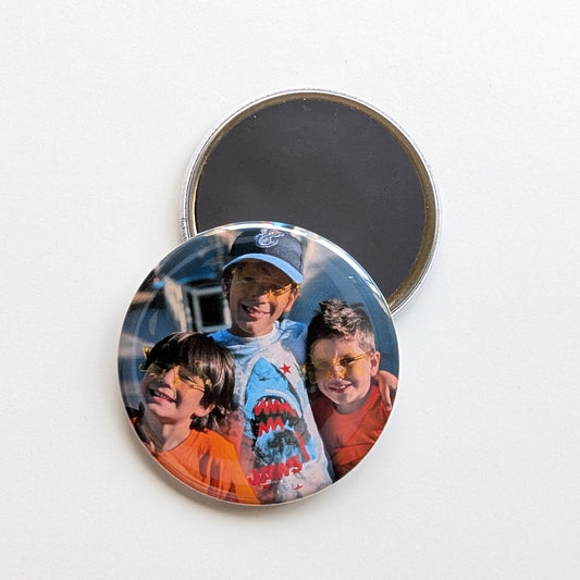 Round photo magnet with a family portrait on a white background