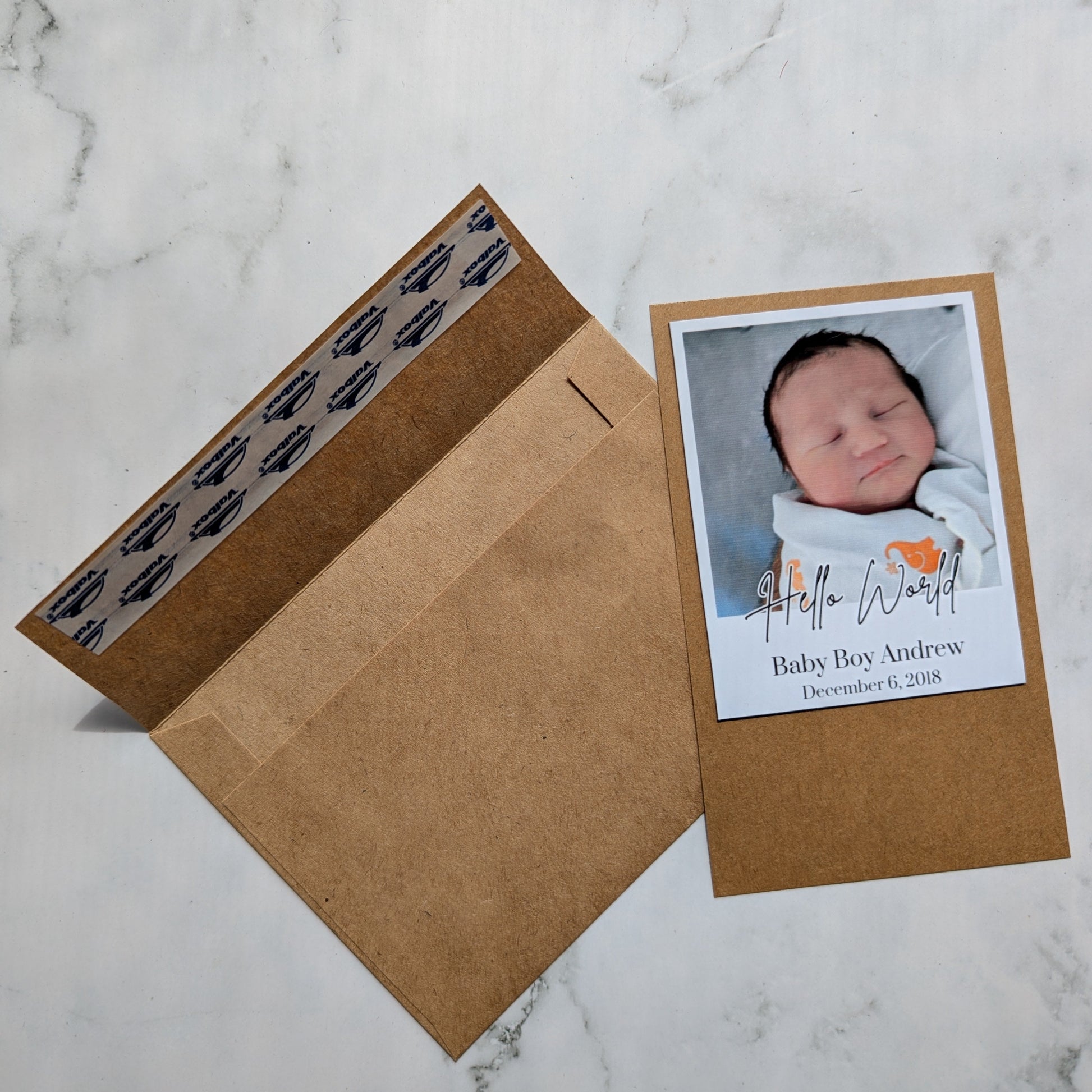 Baby photo magnet with envelope on a marble surface